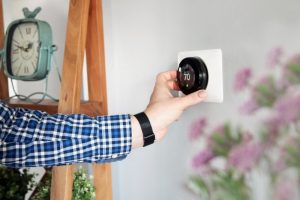 smart-thermostat-on-wall-hand-adjusting