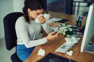 woman-with-kleenex-at-desk